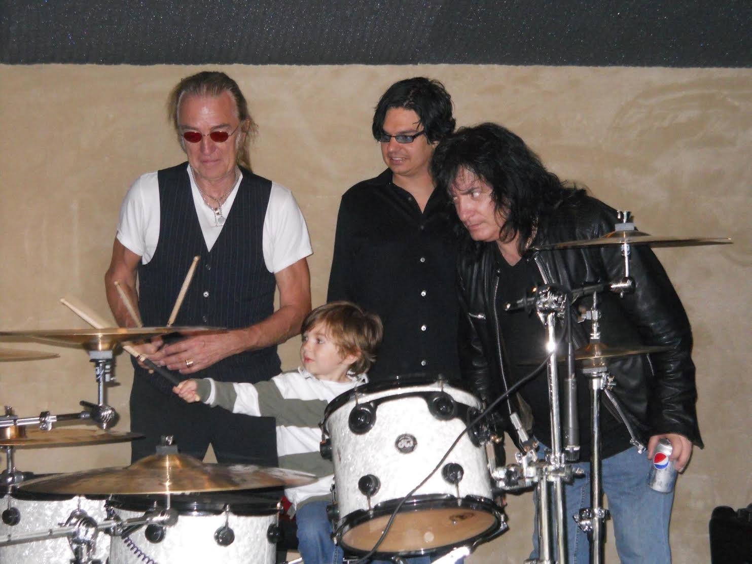 A photo of Julius as a 3-year-old with Roger Earl from Foghat, his father Jules, and Bobby Rondinelli from Black Sabbath.